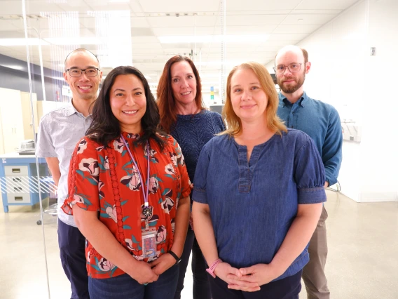Picture of the ITL team standing in front of the clean room viewing windows.