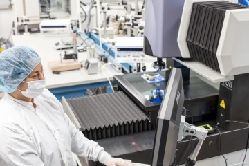 A person operating the VIEW Summit 600 Coordinate Measuring Machine (CMM)